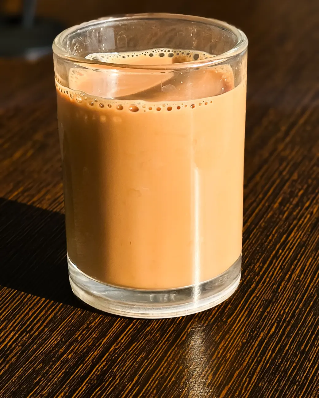 Masala chai being poured into a glass