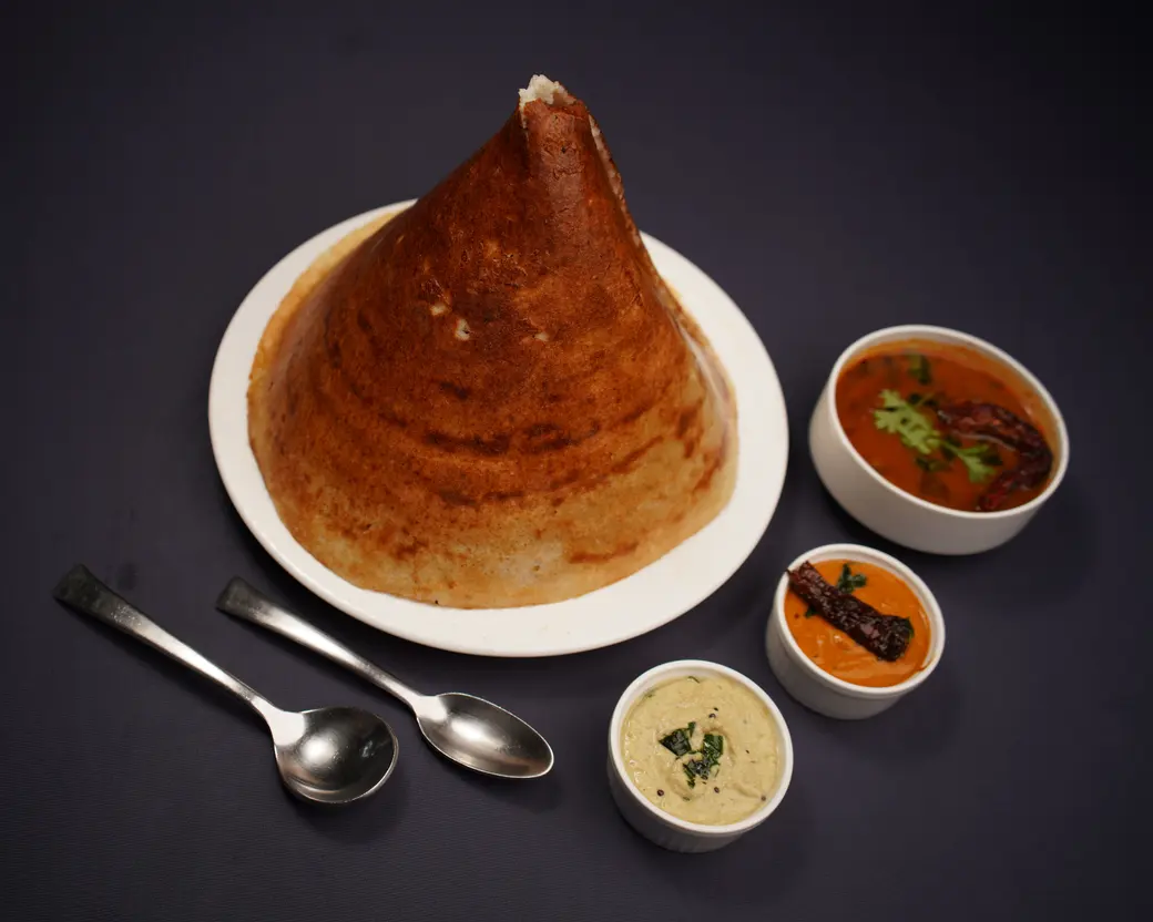The Dosa — Crispy rice and lentil crepe. Sambar, coconut chutney, potato masala. Our amma's recipe, and no, we won't adjust it.